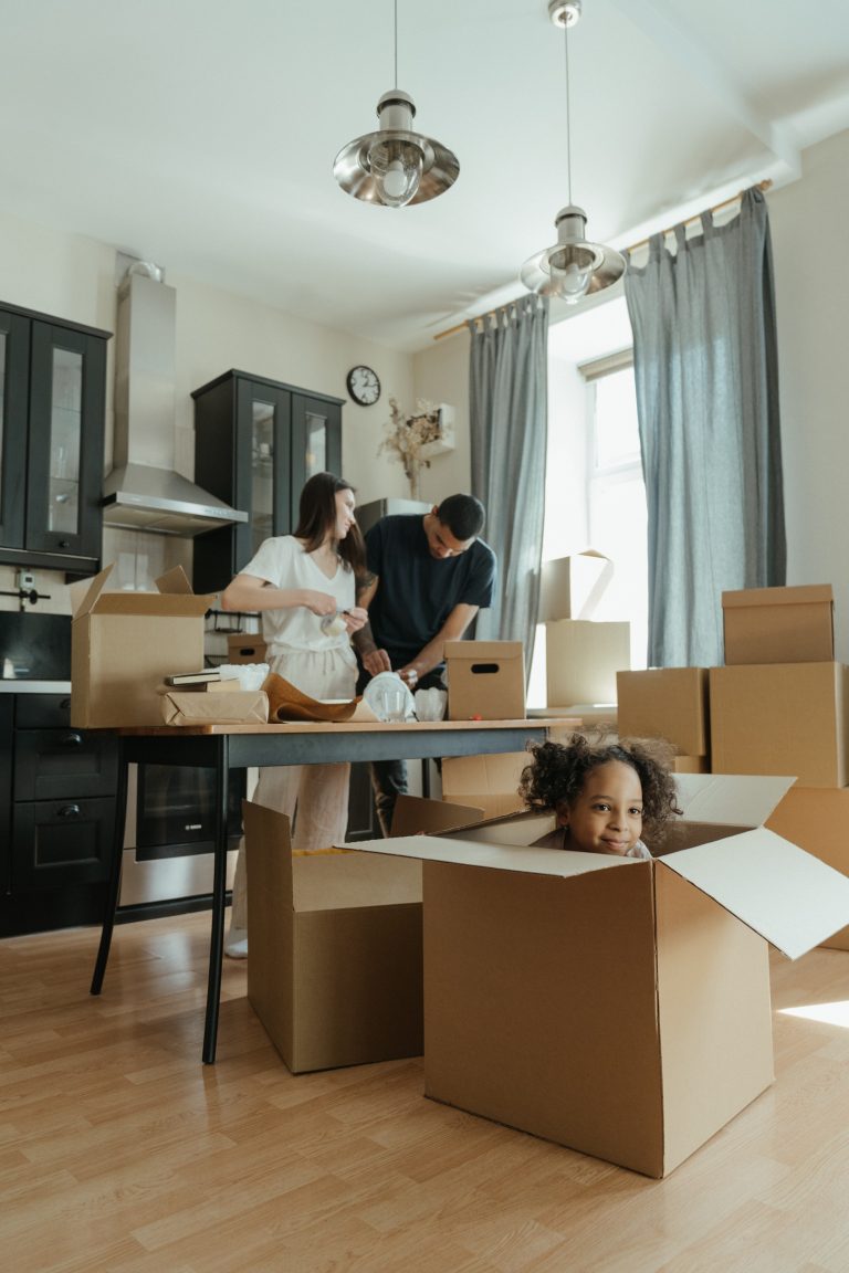 Couple unpack boxes as daughter hides in a box