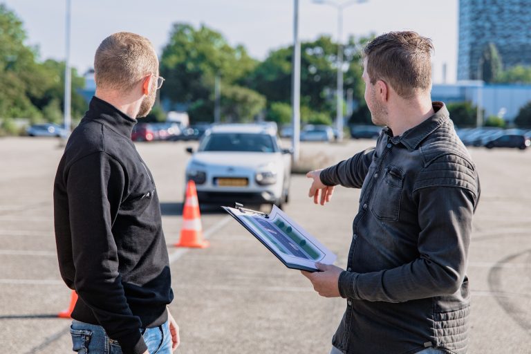 Driving instructor directing new driver