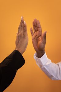 Solicitor high fives client with orange background