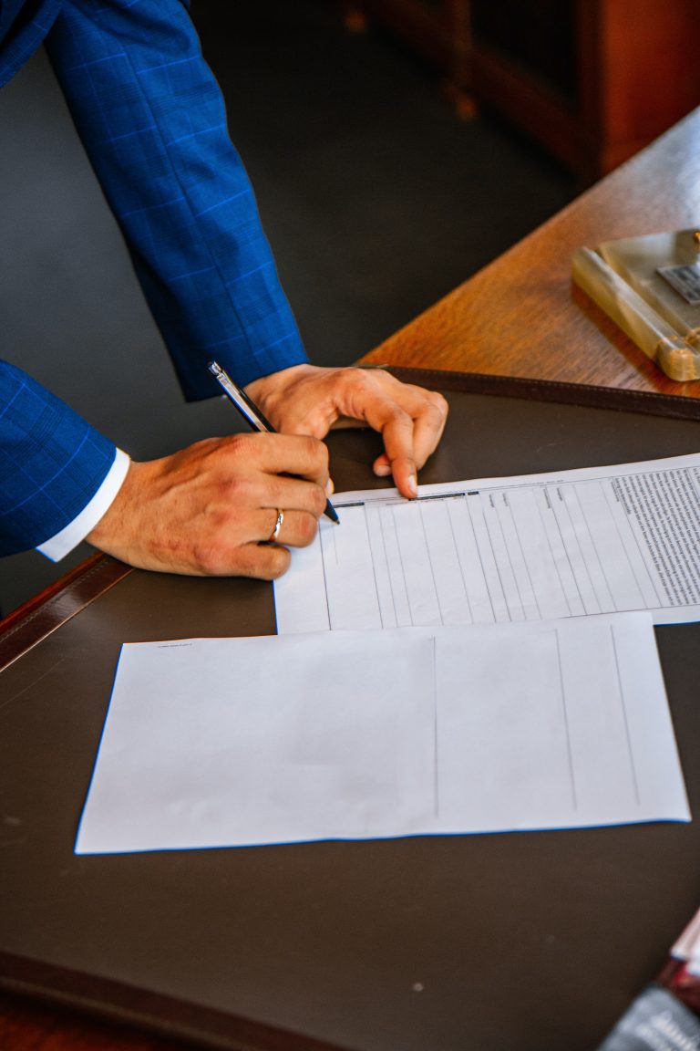 Family lawyers male client in blue suit signs cohabitation agreement