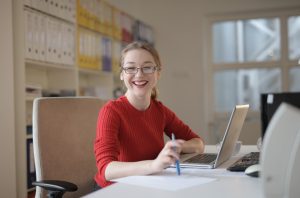 Female lawyer in red smiling at work desk
