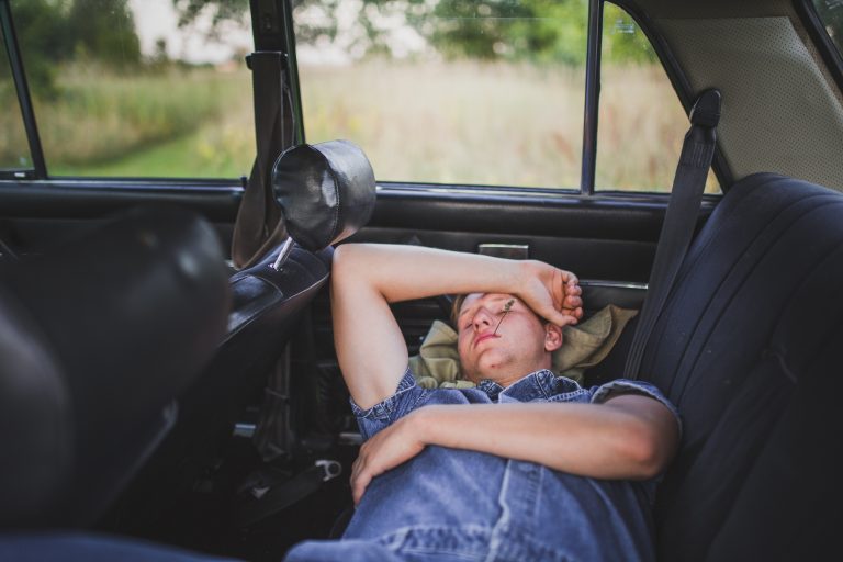 Male client sleeping in vehicle