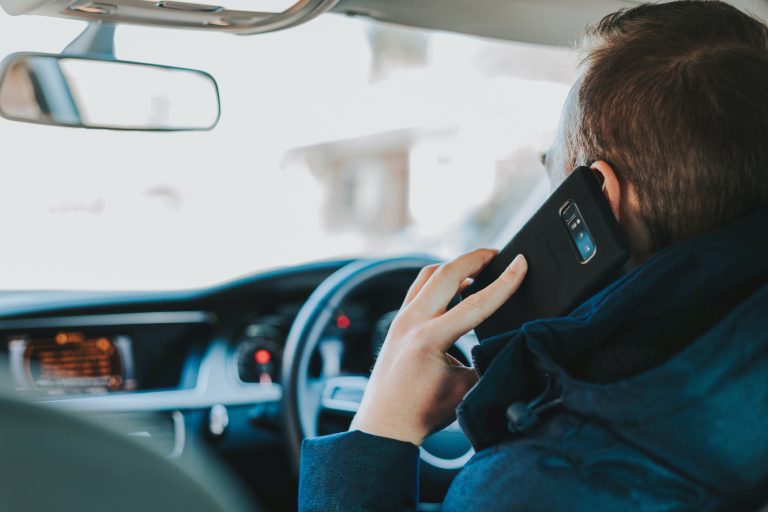 Male driver using mobile phone when driving