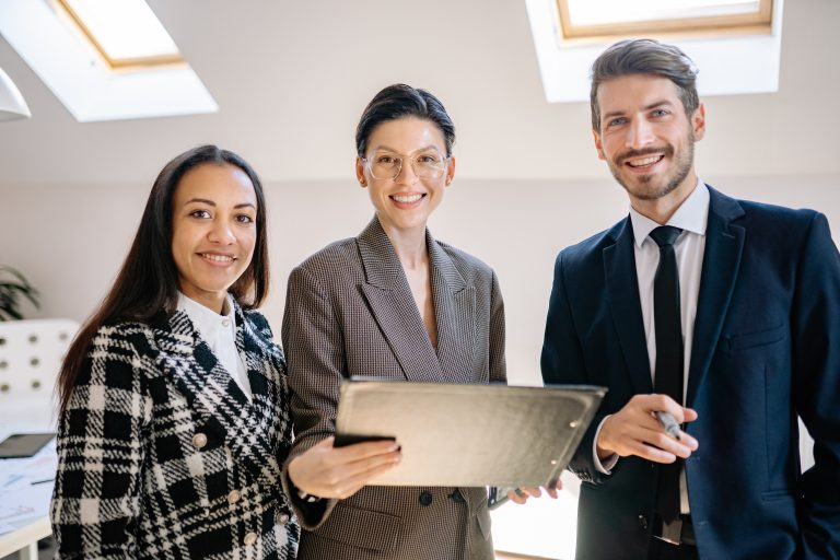 Three Scullion LAW team members smiling holding a binder