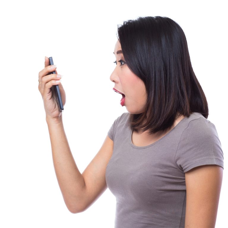 Excited lady is shocked looking at her phone