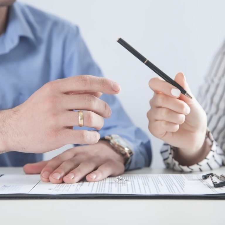 Wife hands pen to husband to sign alternative to divorce papers