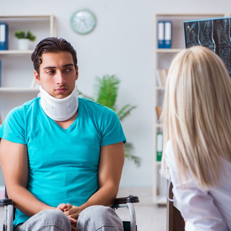 Female Scullion LAW accident claims solicitor takes dictation from injured client in wheelchair and wearing a neck brace