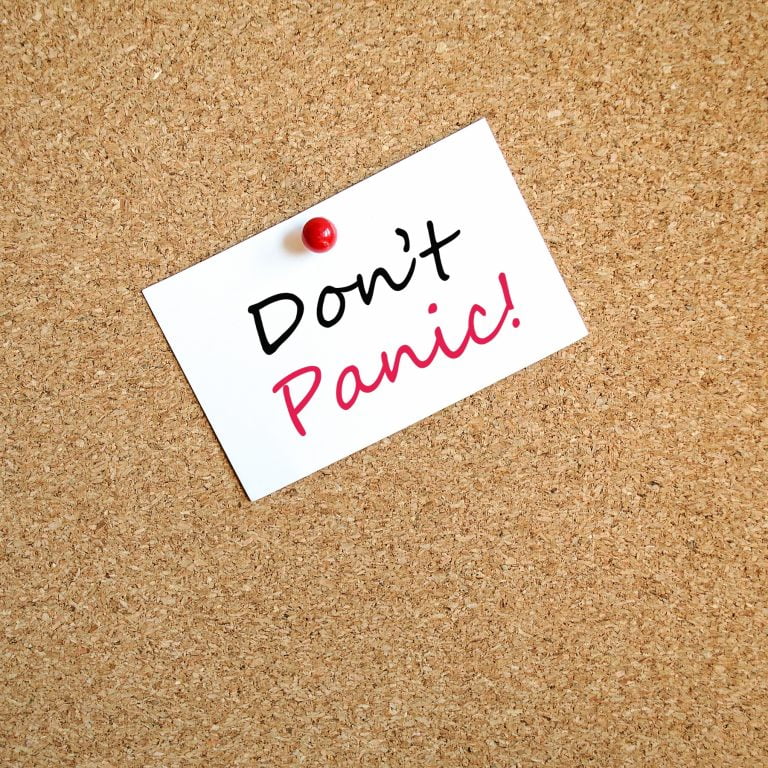 A note pinned to a board reading dont panic