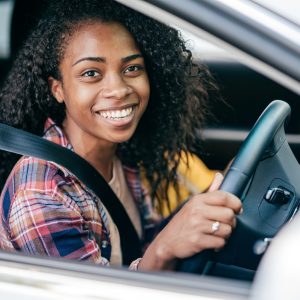 Happy female driver clutching steering wheel