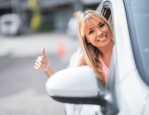 Happy Scullion LAW female driver leans outside her window giving thumbs-up