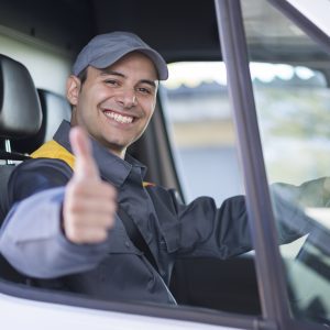 HGV driver smiles and gives thumbs up while driving