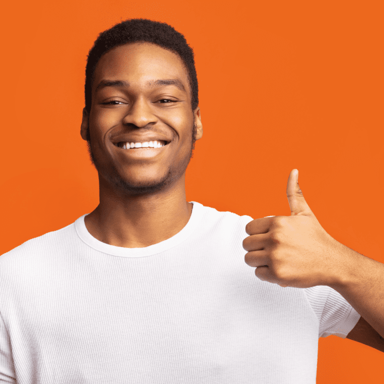 Man gives thumbs up sign standing in front of orange background