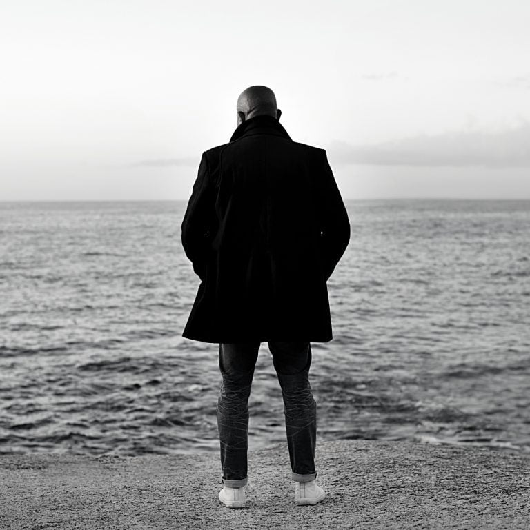 Man stands on the shore staring into the distance