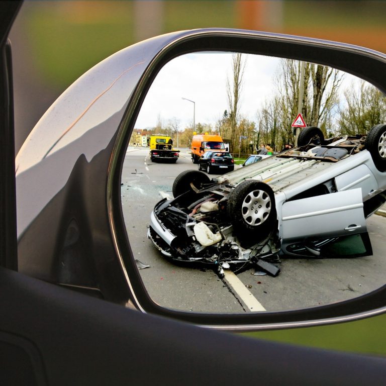 Rear view mirror watching flipped over accident car