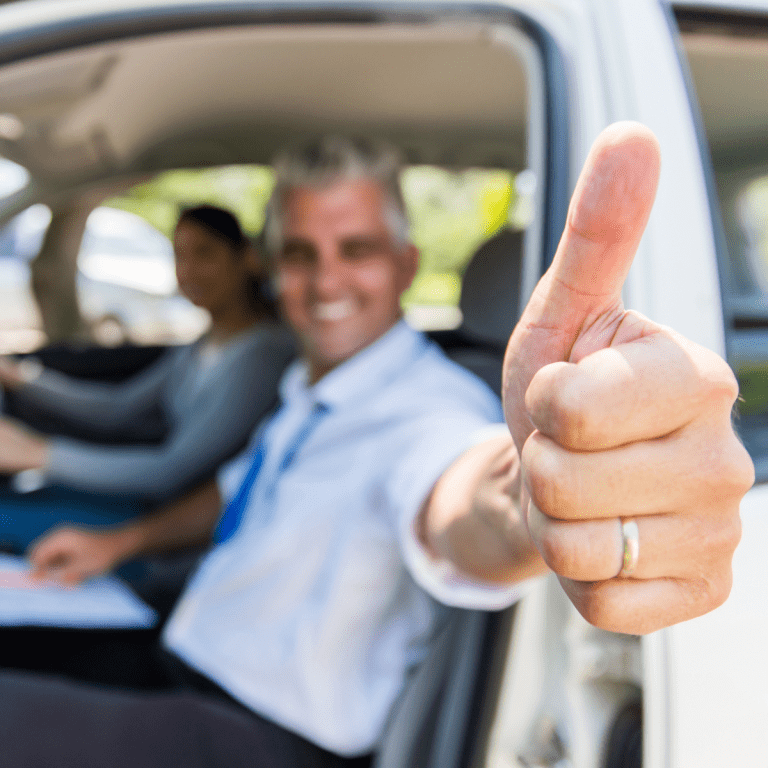 Scullion LAW Road Traffic lawyer giving thumbs up in female drivers passenger seat