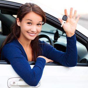 Smiling female Scullion LAW road traffic client holds up key from car window