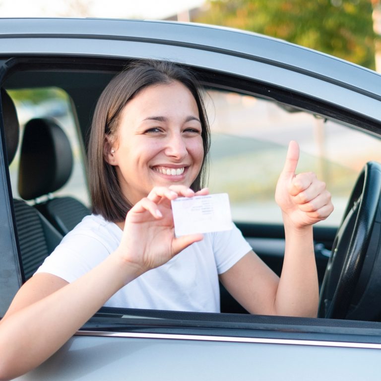 Smiling happy female Scullion LAW road traffic driver thumbs up holding license