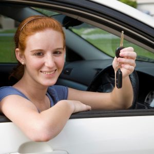 Smiling Scullion LAW female driver shows her car key sitting in car