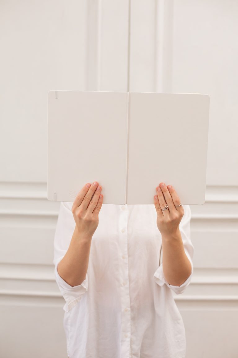Woman hides her face with book