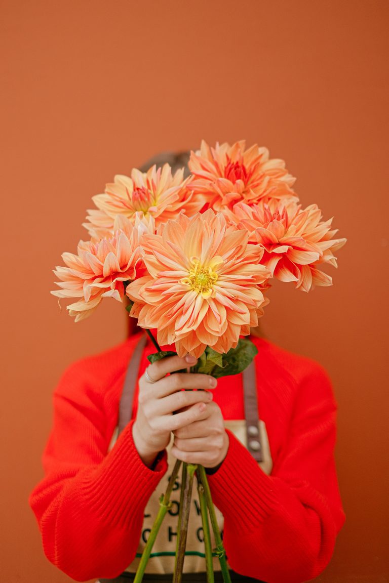 Woman hides her face with flowers