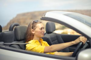 Woman in yellow top driving a convertible