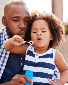 Father and child blowing bubbles