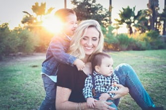 Mother dealing with divorce plays with her kids outdoors