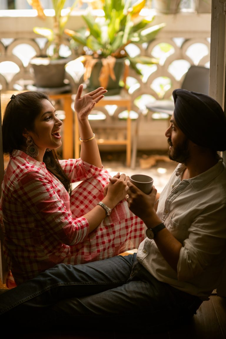 Sihk couple share smile and coffe sitting in the doorway