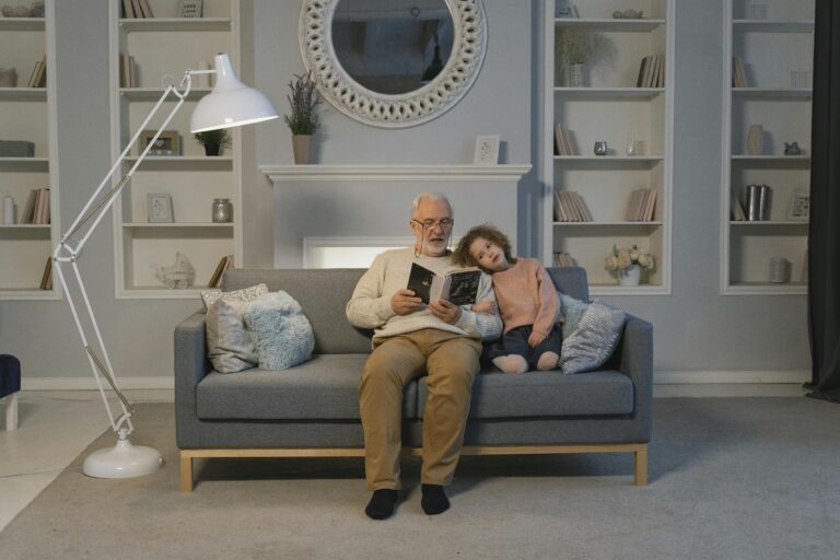 Granddad and Granddaughter on a couch reading