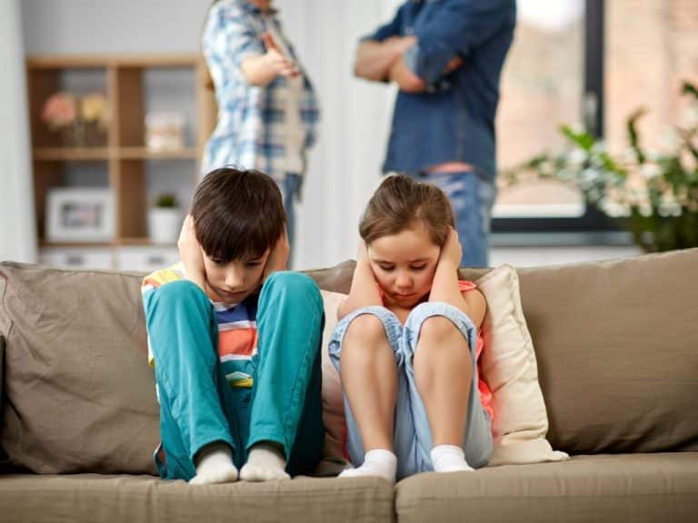 Children covering their ears while parents argue in the background, highlighting Scullion LAW's commitment to resolving family disputes amicably.