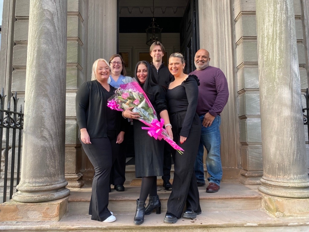 Client Care Team poses in front of Hamilton Office to celebrate Charmaine Trainor's promotion to Head of Sales at Scullion LAW.