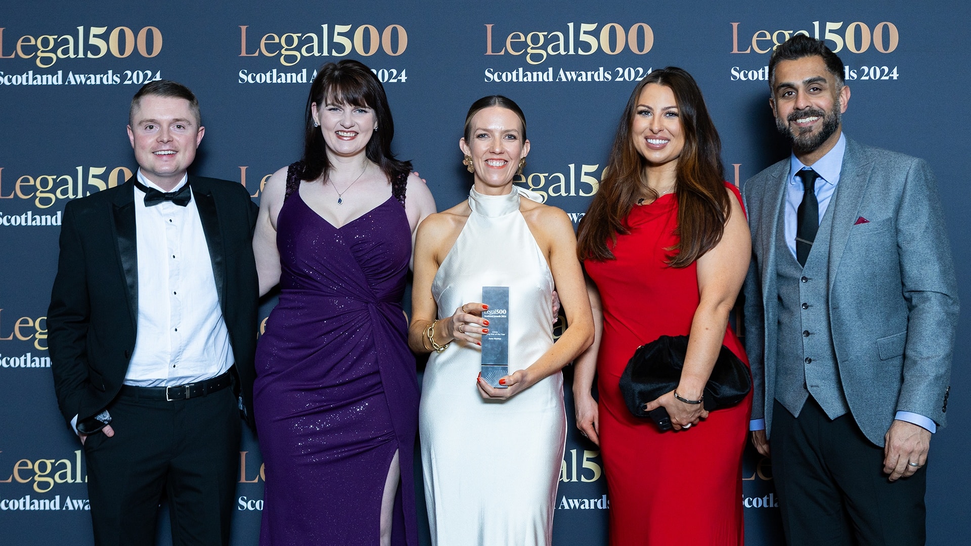 Scullion LAW team celebrates Criminal Law team at Legal 500 Awards 2024. Criminal defence lawyer Anna MacKay stands center with the award for Rising Star of the Year.