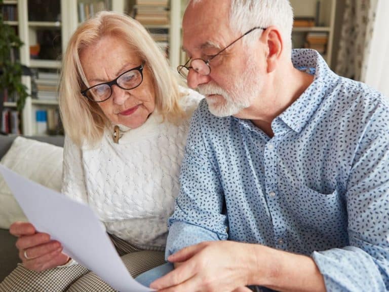 Elderly couple reviewing their Will and Power of Attorney documents prepared by Scullion LAW in their living room.