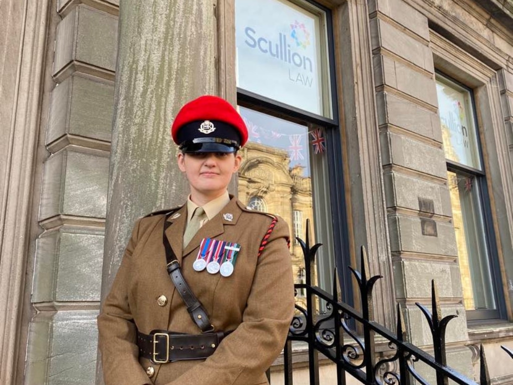 Stephanie Grieve, Criminal Law Solicitor at Scullion LAW, stands outside the Hamilton Office in military dress, nominated for the Military Values in Business Award at the Scottish Forces in Business Awards 2025.