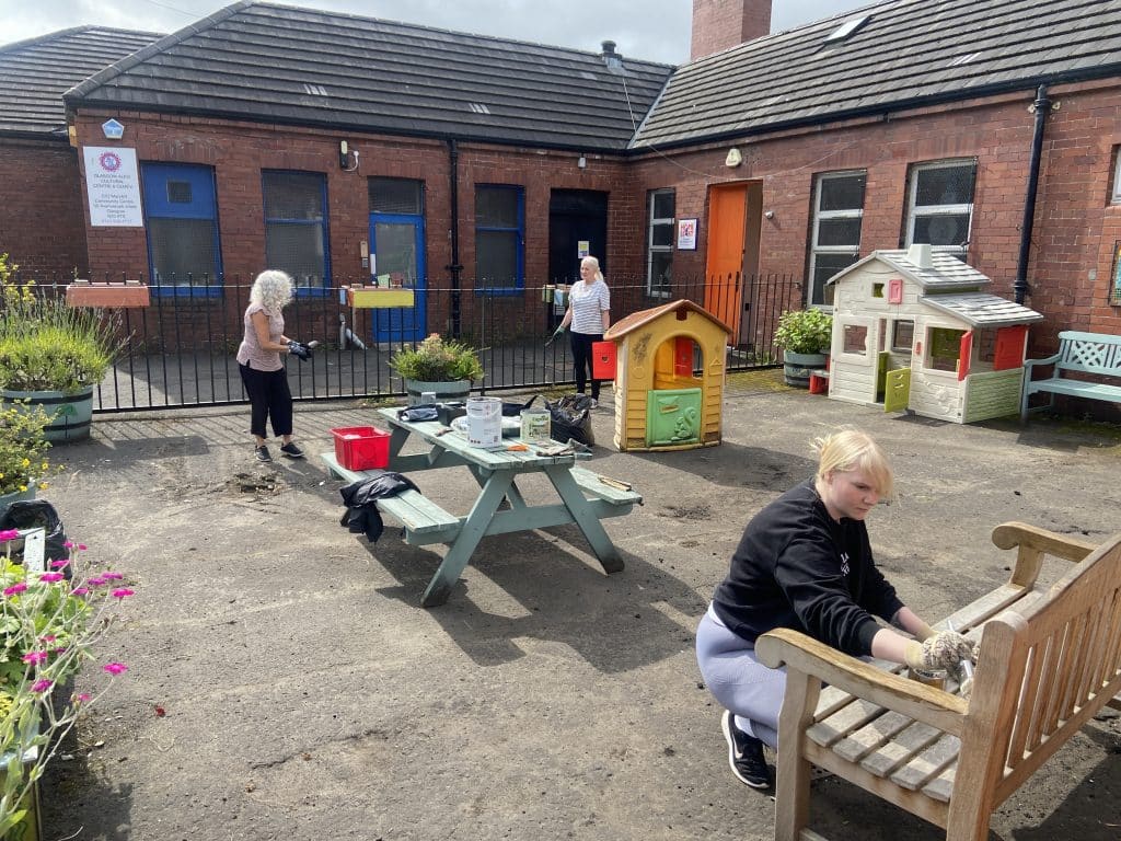 The Family Team from Scullion LAW participating in cleaning, gardening and painting at the Home Start community gardens in Maryhill.