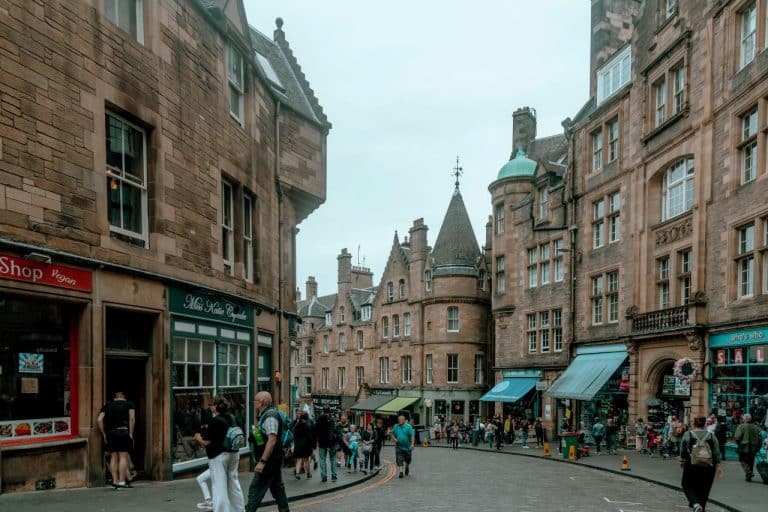 row of houses and shops with people walking buy