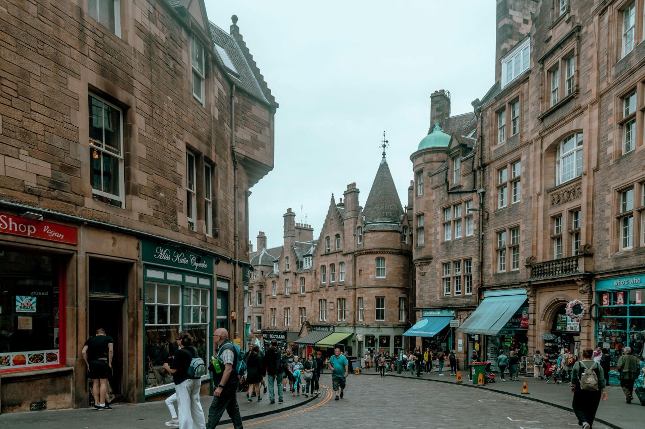 row of houses and shops with people walking buy