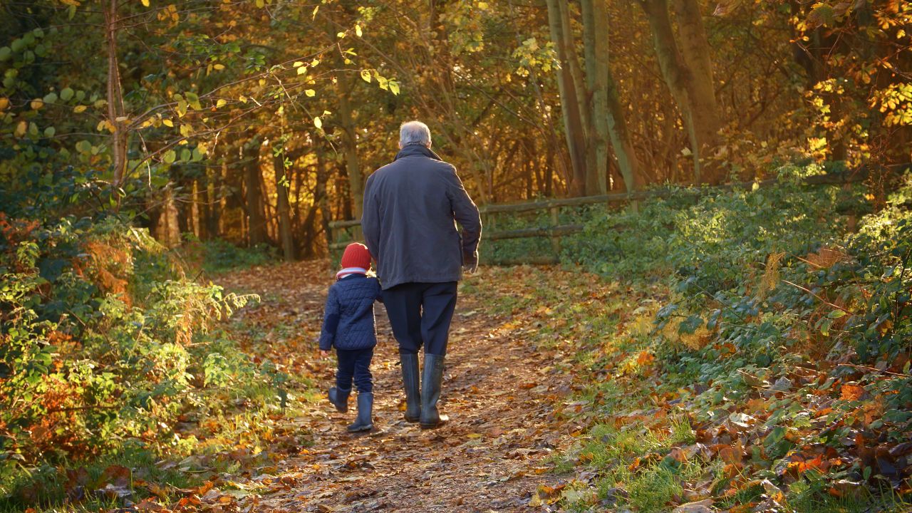 A grandfather walks his grandson though the woods in Scotland safe in the knowledge that Scullion LAW has his future protected.