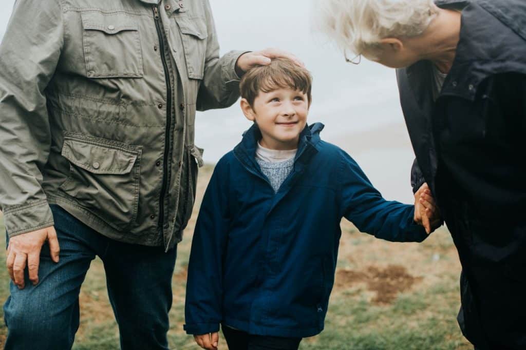 Smiling older couple with their children and grandchildren outdoors
